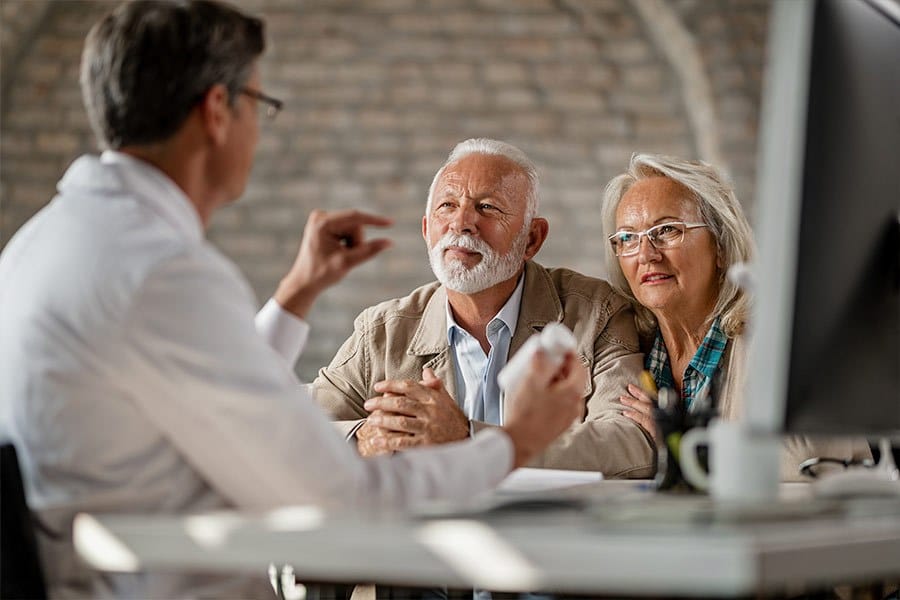 Two patients receiving counseling from a pharmacist.